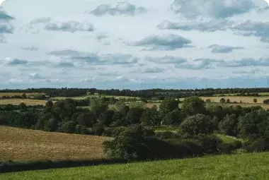 Wide countryside landscape with rolling hills, representing Melissa S.'s property sale to Landacy